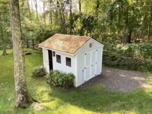 White outbuilding with tapersawn cedar roof