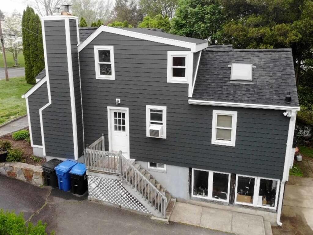 Side view of home with dark gray James Hardie siding replacement 