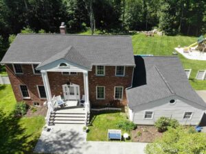 Aerial view of brick home in Armonk, New York with James Hardie siding on addition of home