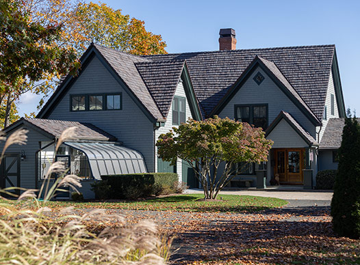 Home with green siding and charcoal roof