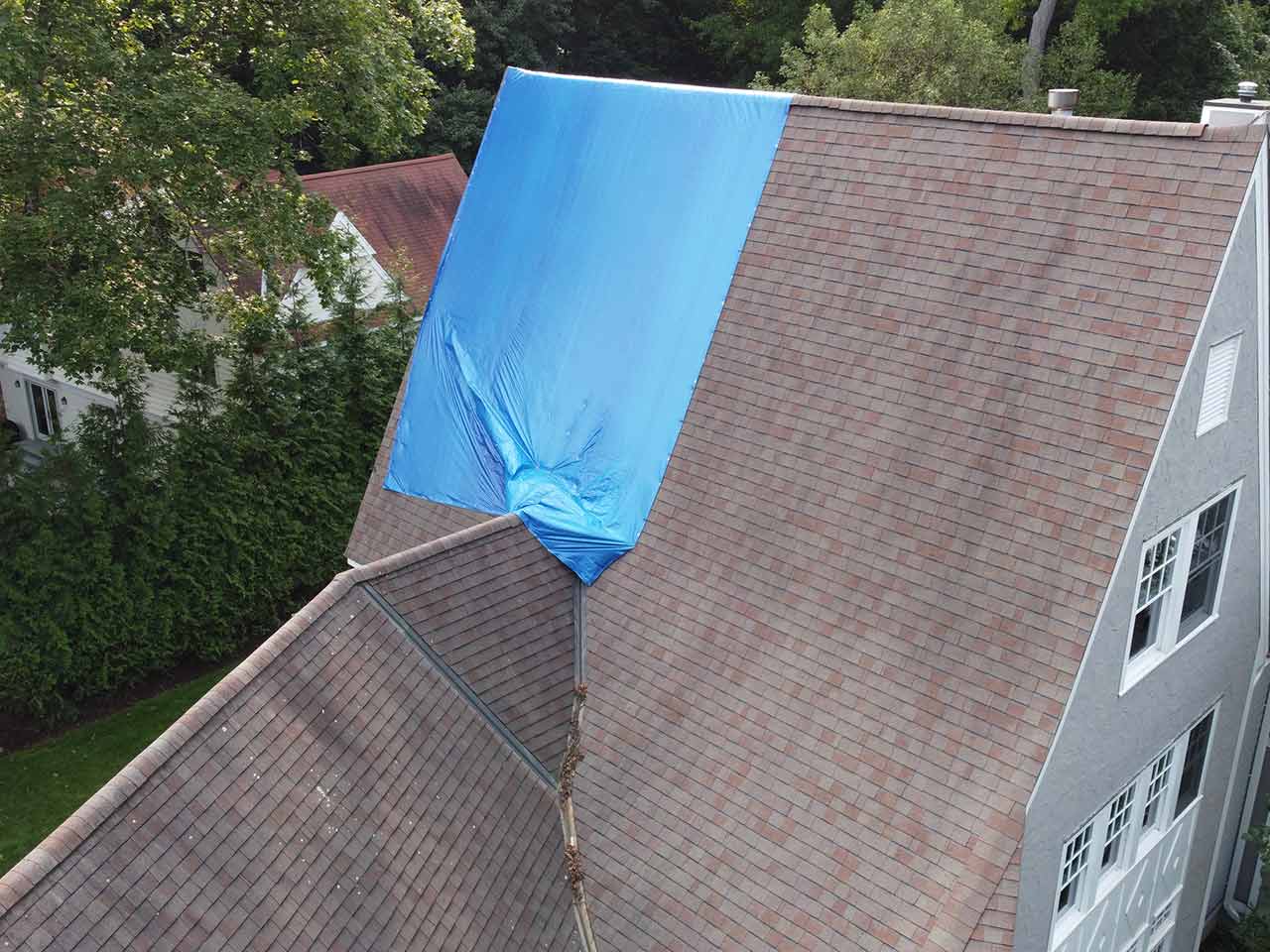 Blue tarp covering damaged section of roof