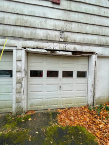 Rotting wooden support beams above garage