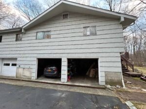 back view of home needing window and siding repair