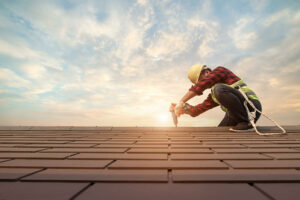 worker on roofing installing shingles