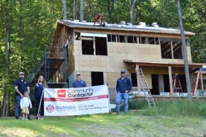 Gunner team standing in front of home being renovated for Habitat for Humanity